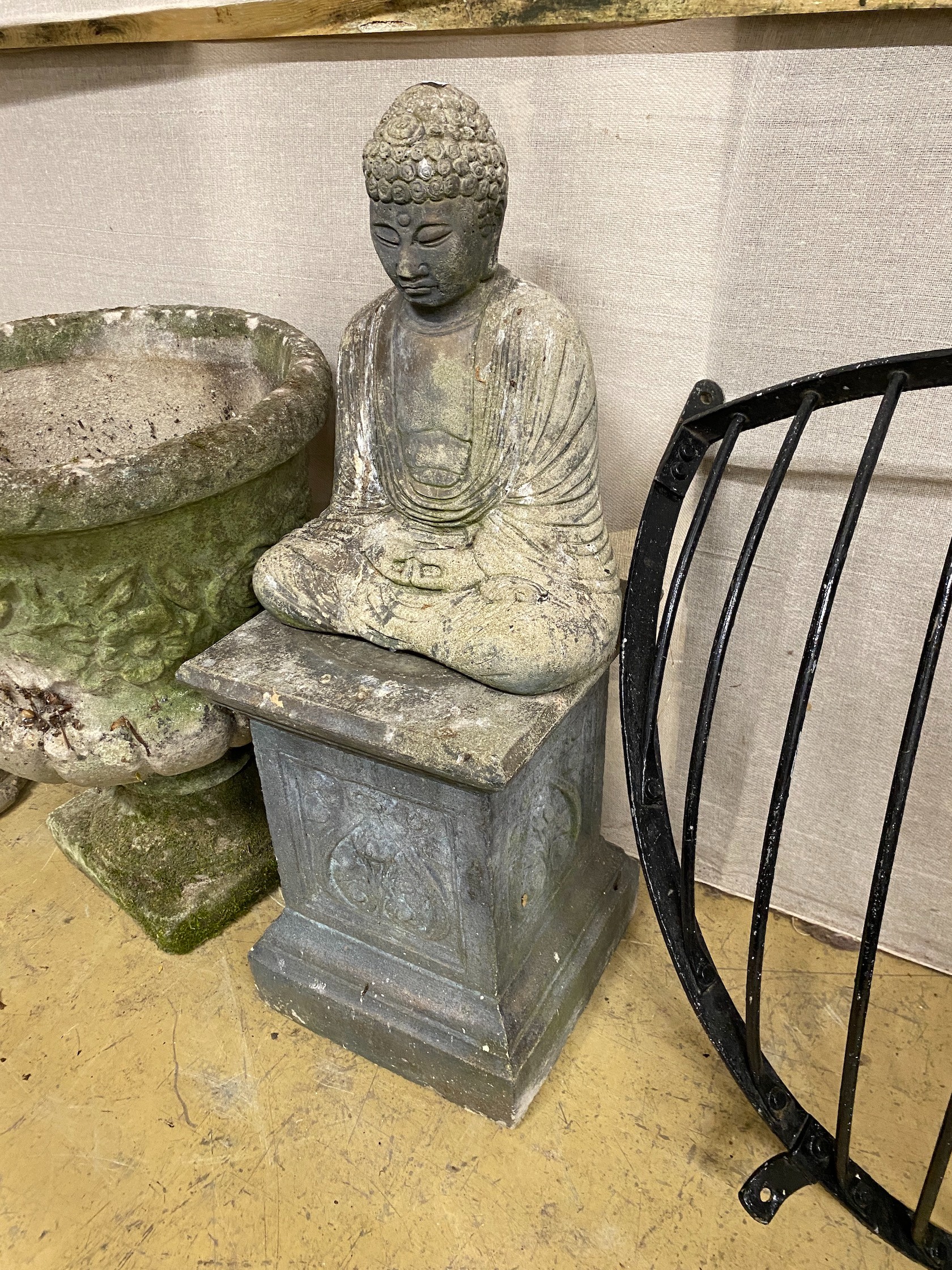 Two reconstituted stone seated Buddha garden ornaments on square plinths, larger height 82cm